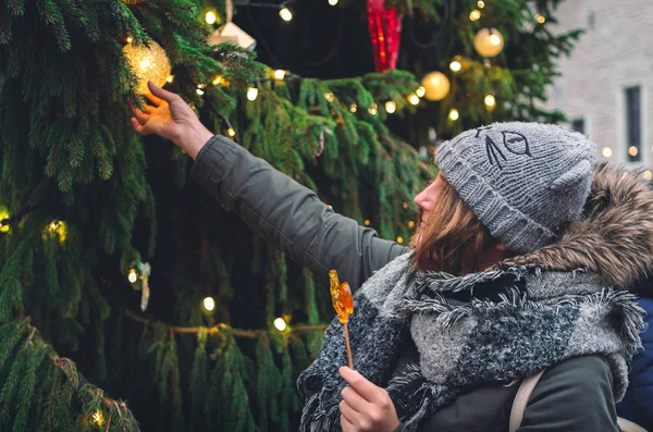 Chica Bonita Con Gallo Caramelo Tocando Gran Árbol Navidad Mercado —  Fotos de Stock