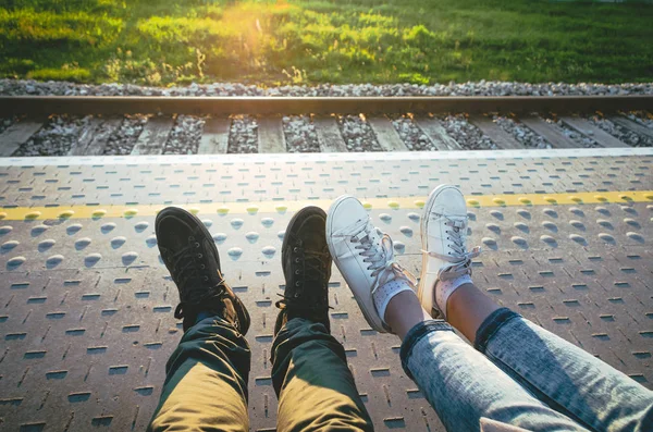 Personal perspective of girl's and boy's legs on a train platfor