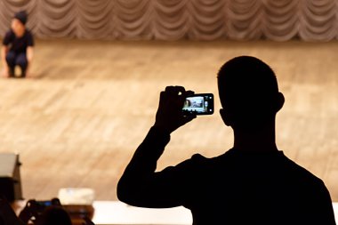 Bir konser bir cep telefonu alarak bir adam silüeti