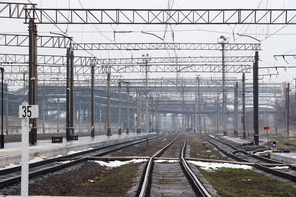 Industriområde och järnvägen. Järnvägen skenor gå in avståndet mellan järnvägsstationen och industriområde. — Stockfoto