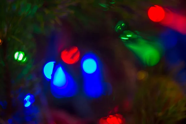 Разноцветные размытые огни новогодней гирлянды и летящие мыльные пузыри как красивый фон — стоковое фото