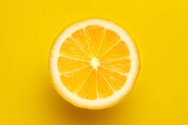 Sarı arka planda dilimlenmiş parlak sulu limon..