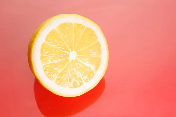 Limón jugoso brillante en rodajas sobre un fondo rojo . —  Fotos de Stock
