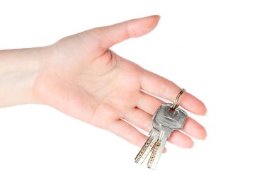 Kadın eli, evin ya da evin anahtarlarını beyaz arka planda tutuyor.