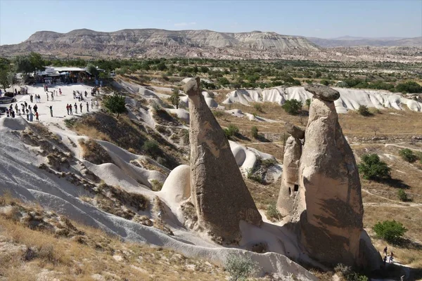 Les touristes visitent quelques-unes des célèbres cheminées de fées en Cappadoce — Photo