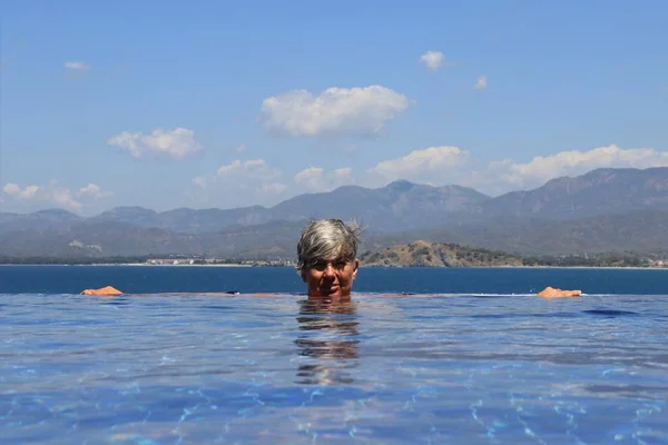 An english lady relaxing in a infinity swimming pool — Stock Photo, Image