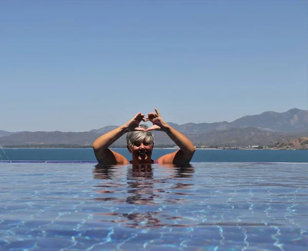 An english lady relaxing in a infinity swimming pool — Stock Photo, Image