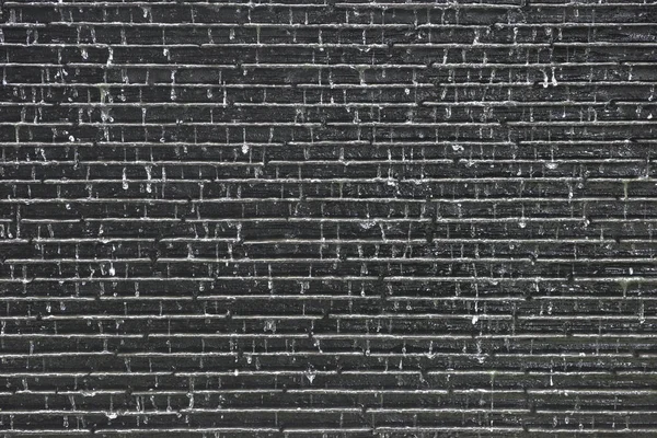 water fall on old brick grey wall background.