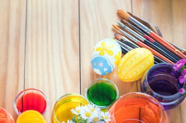 Mutlu Paskalya günleri. Renkli yumurtalar ve çiçekler. Bir dizi besin boyası, akrilik boya fırçası..