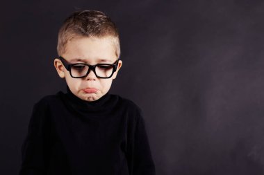 Portrait of sad child in pullover and glasses clipart