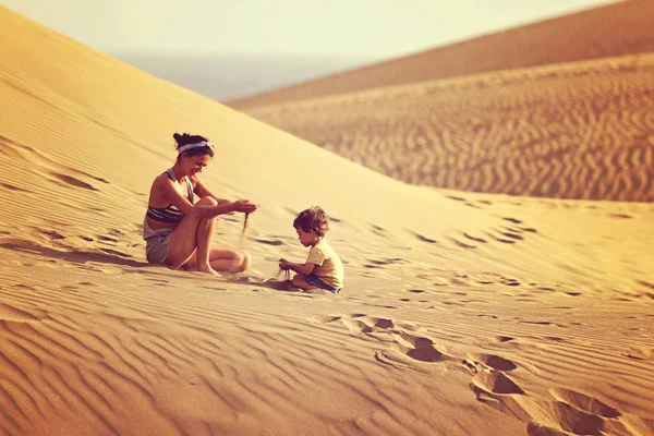 Mutter mit Sohn spielt mit Sand in einer Wüste auf Gran Canaria — Stockfoto