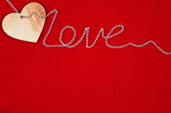 Corazón y cadena de madera sobre fondo rojo para el día de San Valentín — Foto de Stock