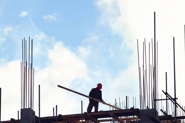 Tým pracovníků stavební plyše s modrou oblohou na pozadí. Nový mrakodrap. Stock Obrázky