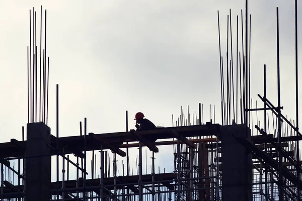 Équipe de travailleurs construisant pile avec ciel bleu sur les arrière-plans. Nouveau gratte-ciel . Photos De Stock Libres De Droits