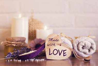 Spa ve sağlıklı yaşam ayarı beyaz havlu, sünger, mum, lavanta ve ahşap kalp üzerinde tuğla duvar arka plan ile. Sevgililer kartpostal
