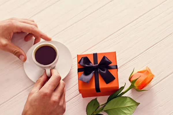 Jeune homme qui attend dans le café avec présent orange et rose orangée. Boire du café — Photo