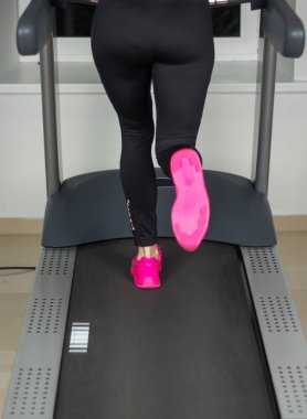 spor salonunda bir koşu bandı üzerinde kadın bacakları uygun