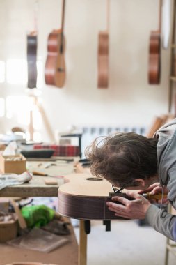 Grodno, Belarus - 18 Ocak 2017. Ciddi profesyonel gitar üreticisi ile bitmemiş gitar Atölyesi'nde çalışma