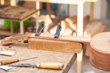 Tablo Araçları ile atölyesinde bitmemiş gitar