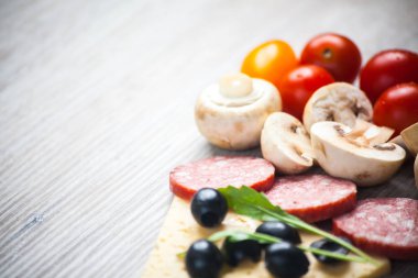 Yaratıcı Kompozisyon malzemeler domates, peynir, salam, mantar, roka, zeytin bir dilim pizza şeklinde