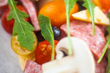 Yaratıcı Kompozisyon malzemeler domates, peynir, salam, mantar, roka, zeytin bir dilim pizza şeklinde