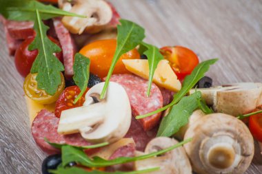 Yaratıcı Kompozisyon malzemeler domates, peynir, salam, mantar, roka, zeytin bir dilim pizza şeklinde