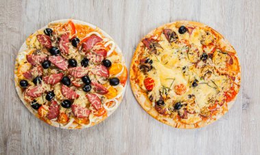 Üst iki Pizza mantar, zeytin ve domates, sosis ile görüntüleyin. Biberiye ve taze sebze. Taze ev yapımı