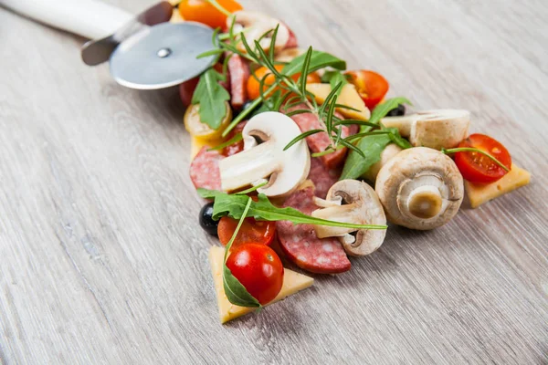 Composición creativa de ingredientes, tomates, queso, salami, champiñones, rúcula, aceitunas, de un pedazo de pizza — Foto de Stock