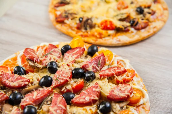 Κορυφαία προβολή δύο πίτσα με μανιτάρια, ντομάτες, ελιές και λουκάνικα. Δεντρολίβανο και φρέσκα λαχανικά. Φρέσκο σπιτικό — Φωτογραφία Αρχείου