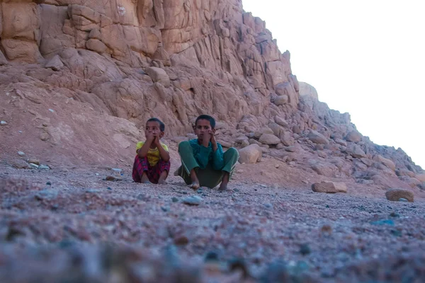 Sharm El Sheikh, Egypt - červenec 9, 2009. Dvě děti sedí v poušti a při pohledu do dálky — Stock fotografie