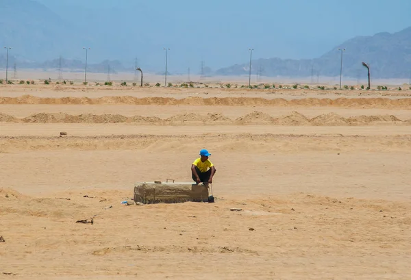 SHARM EL SHEIKH, EGIPTO - 9 DE JULIO DE 2009. un hombre sentado en el desierto — Foto de Stock
