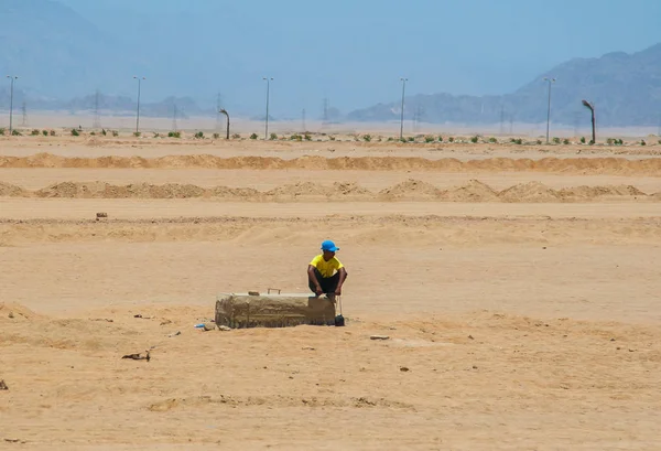 SHARM EL SHEIKH, EGIPTO - 9 DE JULIO DE 2009. un hombre sentado en el desierto —  Fotos de Stock