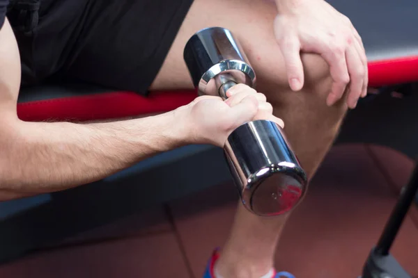 Fisiculturista exercitando-se com pesos bumbbells no ginásio — Fotografia de Stock