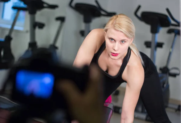 Sexy ragazza atletica facendo esercizi di stampa manubri. Fitness donna muscolosa in nero abbigliamento sportivo allenamento sulla panchina in palestra — Foto Stock
