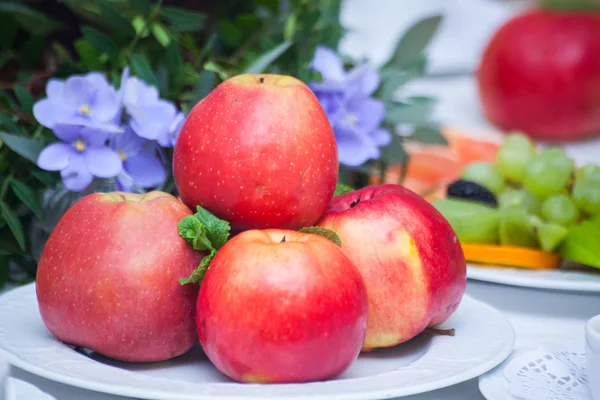 Beyaz masaya bir tabak içinde kırmızı elmalar, — Stok fotoğraf