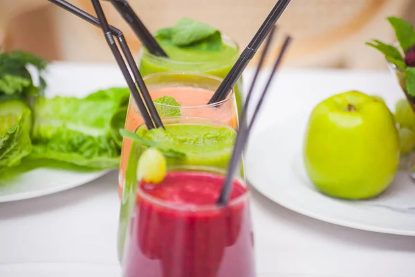 Red and green healthy smoothies with fresh ingredients on table. — Stock Photo, Image