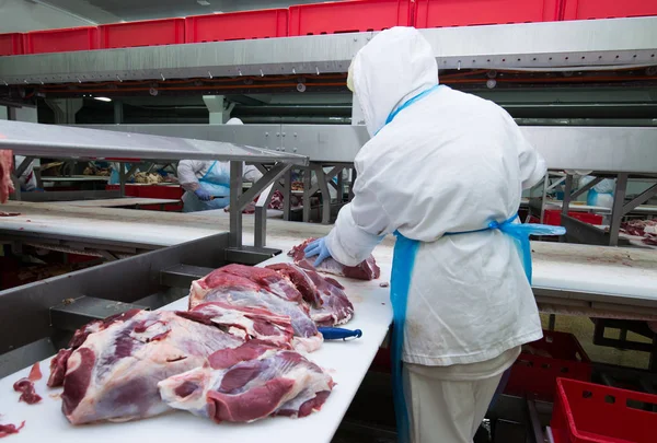 Cutting meat slaughterhouse workers in a meat factory. — Stock Photo, Image