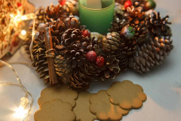 Christmas cookies and candlestick decorated with cones and berries on the table. close-up — Stock Photo, Image