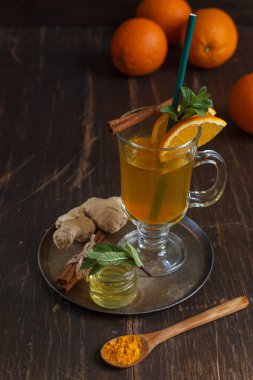 Nane, portakal ve tarçınla süslenmiş bir pipetle İrlanda bardağındaki baharatlarla çayı güçlendirmek