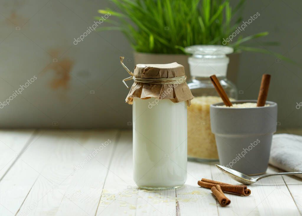 Rice vegetable milk, lactose-free in a paper-wrapped bottle on a white wooden table, blurred background, horizontal orientation