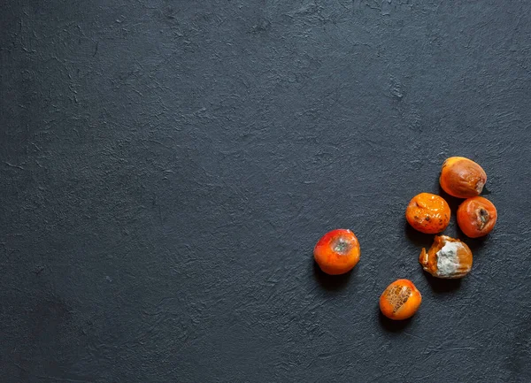 Küflü çürük kayısılar ve siyah kabataslak zemin üzerinde lekeler.