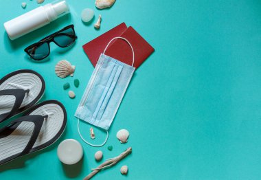 Boş aksesuarları, pasaportları ve imzalanacak bir yeri olan koruyucu bir tıbbi maskesi olan mavi bir arka plan.