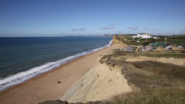 Burton Bradstock Dorset Англия красивое юрское побережье с голубым небом и морем летом — стоковое видео