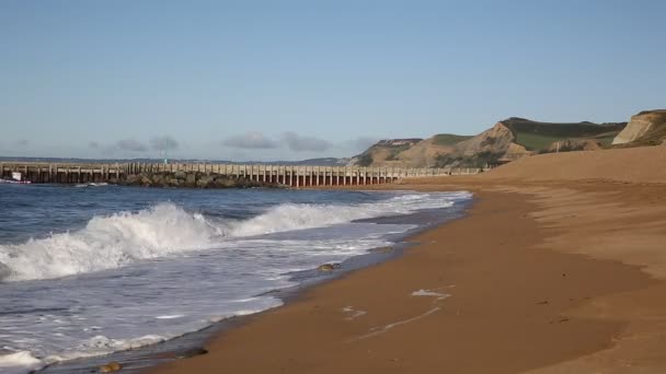 West Bay Dorset Engeland uk strand en golven met het oog op de west-richting van Golden Cap — Stockvideo