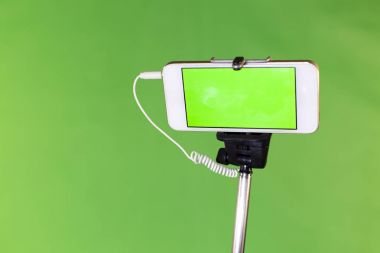 Selfie çubuk yeşil bir arka plan üzerinde