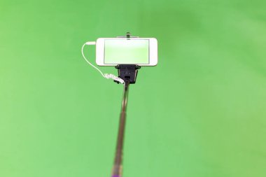 Selfie çubuk yeşil bir arka plan üzerinde