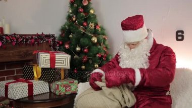 Noel Baba hediye çantasından alır..