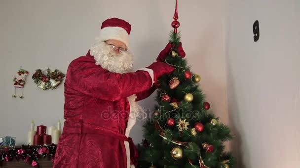 Papá Noel está decorando un árbol de Navidad . — Vídeos de Stock