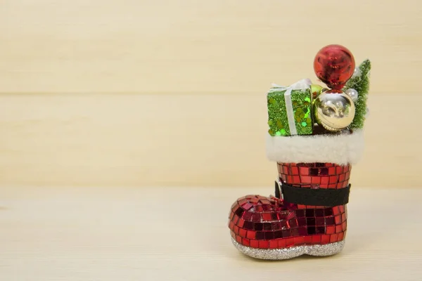Stiefel mit Geschenken für Weihnachten auf dem Hintergrund helles Holz. — Stockfoto