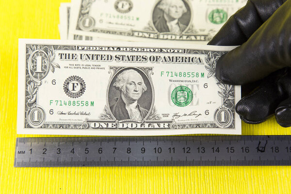 Преступник в перчатках и долларах
.